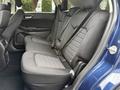 A 2017 Ford Edge with black upholstery and seating for three in the rear, featuring seat belts and a sleek interior design