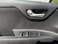 Close-up of the interior door panel of a 2018 Kia Rio5 featuring a door handle and power window controls