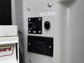 A control panel featuring switches for exterior lights and a power outlet mounted on the interior wall of a vehicle