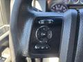 A close-up of the steering wheel controls of a 2016 Ford F-550 featuring buttons for cruise control and navigation settings