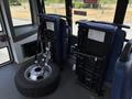 A 2020 Chevrolet Express with two folded seats and a spare tire displayed in the foreground