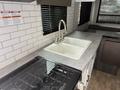 A kitchen countertop featuring a double sink and a stove top with burners in a 2022 Keystone Hideout RDWE 20RDWE camper