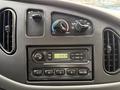 Dashboard of a 2008 Ford Econoline featuring climate control knobs and an AM/FM radio with a digital clock display