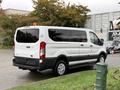 A white 2018 Ford Transit van parked with sliding side doors and a high roof design
