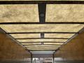 Interior view of a 2017 Hino 338 truck showing the underside of the cargo area roof with overhead lights and a wood paneling finish