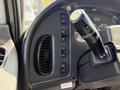 Close-up of the control panel in a 2015 Freightliner M2 106 featuring various buttons and a gear shift lever