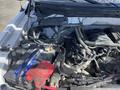Engine compartment of a 2012 Ford F-150 featuring a battery and various engine components with visible wires and hoses
