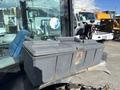 A gray toolbox mounted on the side of a 2010 New Holland T4050 tractor showing signs of rust and age