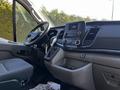 Interior view of a 2023 Ford Transit highlighting the steering wheel dashboard controls and seating area