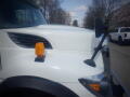 A white 2016 International WorkStar 7500 truck featuring a prominent front hood an orange warning light and a side mirror