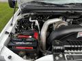 An engine compartment of a 2007 Ford F-550 showing the engine components including a turbocharger battery and various hoses and pipes