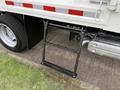 A black metal ladder attached to the side of a white 2014 Hino 195 truck