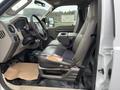 Interior of a 2010 Ford F-250 SD showing the driver's seat and console with visible wear on the seat's leather and a rubber floor mat