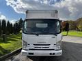 A 2016 Isuzu NPR truck with a boxy cargo area and front-facing headlights standing still