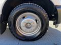 A close-up of a tire and wheel from a 2011 Ford F-350 SD showing the silver rim and black treaded tire with the brand name Teradamax A/T