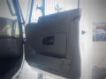 A close-up of the door panel of a 2016 International WorkStar 7500 showing the interior handle and storage compartment