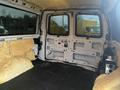 Interior of a 2012 Chevrolet Express van showing exposed insulation on the walls and an empty floor space with no seats or cargo present