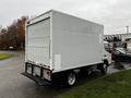 A white 2012 Mitsubishi Fuso FE truck with a boxy cargo area and no visible branding parked on a roadway