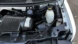 Close-up view of the engine bay of a 2005 Chevrolet Express showing the air intake manifold coolant reservoir and various engine components