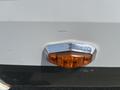 Close-up of a 2013 Outdoor Wind River vehicle's amber side marker light with chrome trim and a visible scratch on the surface