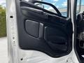 Interior door panel of a 2020 Hino 338 featuring a black plastic finish with a handle and a speaker grille