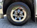 A chrome wheel of a 2016 GMC Sierra 1500 showcasing the tire tread and intricate details of the wheel rim