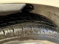 A close-up view of a 2008 Suzuki Carry's tire showing tread patterns and water droplets on the surface