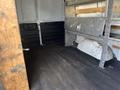 Interior of a 2016 GMC Savana cargo van with wooden shelves and a flat black floor