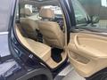A 2009 BMW X5 interior showing beige leather seats and a view into the cabin from the open rear door