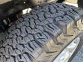 Close-up of a rugged tire tread on a 2014 Ford F-250 SD showcasing deep grooves and patterns designed for traction and off-road performance