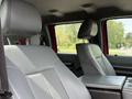 The interior of a 2013 Ford F-550 featuring gray leather bucket seats with headrests and a center console between them