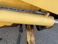 A yellow hydraulic cylinder from a 2007 Komatsu WB156PS-5 with a metal piston rod and visible wear on the surface