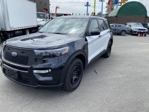 A black and white 2021 Ford Explorer with a sleek design and black alloy wheels parked at an industrial location