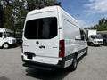 A 2019 Mercedes-Benz Sprinter van with a white exterior and rear sliding doors viewed from the back