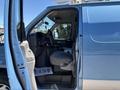 A 2008 Ford E-350 with the driver's side door open showing the interior seating and dashboard area
