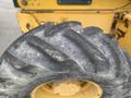 Close-up of a rugged tire from a 2012 John Deere 310SJ showcasing deep treads and weathered texture designed for heavy equipment and construction use