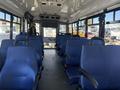 Interior of a 2020 Chevrolet Express bus featuring blue fabric seats arranged in rows with seatbelts attached