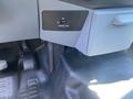 Interior dashboard controls of a 2015 Ford F-450 SD including a button for passenger airbag settings and foot pedals visible on the floor