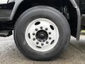 Close-up of the wheel of a 2007 GMC F7500 featuring a white rim and a wide black tire with visible treads and lug nuts