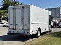 A white 2019 Freightliner MT45 delivery truck with a boxy cargo area and rear double doors parked on grass