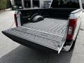 A 2020 Ford F-350 Super Duty with its tailgate down revealing a textured truck bed and a spare tire mounted against the side