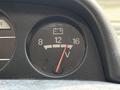 A dashboard voltmeter displaying a needle between 12 and 16 volts in a 2003 Mitsubishi Delica