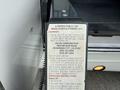 A 2010 Ford Econoline with a wheelchair lift attached, featuring a visible warning and operational instructions on the lift's control panel