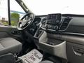 Interior of a 2023 Ford Transit showcasing the dashboard center console gear shift and driver's seat with controls and displays