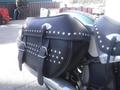 A leather saddlebag with studs attached to a 2009 Harley-Davidson Flstc motorcycle