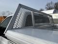 A 2016 Ford F-350 SD with a metal mesh headboard mounted on the truck bed