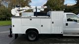 A white 2007 Ford F-550 with a utility body and a mounted crane on the top