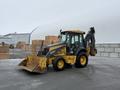 A 2011 John Deere 310SJ 4x4 Wheel Loader with an extended hoe and a 4 in 1 bucket is positioned on a flat surface among stacks of wooden materials