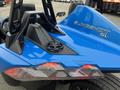 A blue 2020 Polaris Slingshot with a sleek design showcasing its rear light assembly and the SL logo embossed on the body