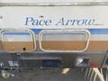 A 1987 Chevrolet Fleetwood Pace Arrow with a beige and blue color scheme featuring the name "Pace Arrow" displayed prominently on the side